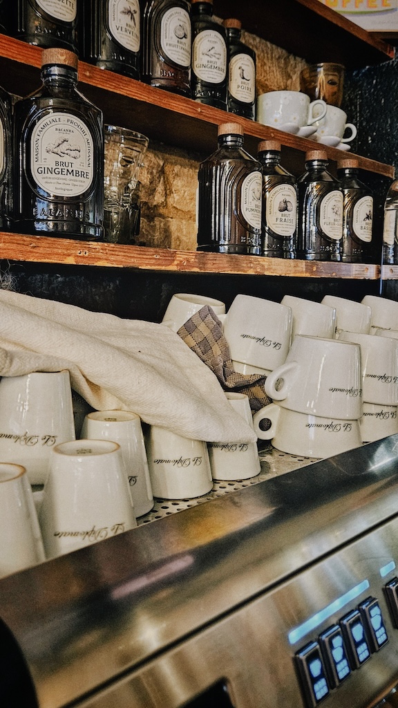 Tasses siglées Le Diplo et sirops artisanaux sur la machine à café de la brasserie à Caen